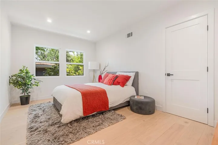 Guest bedroom with large window and abundant natural light.