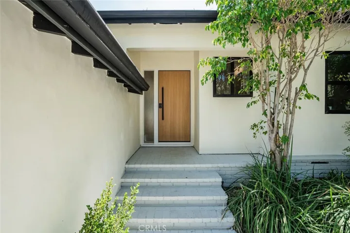 Welcoming front entry with modern architecture and landscaped approach.