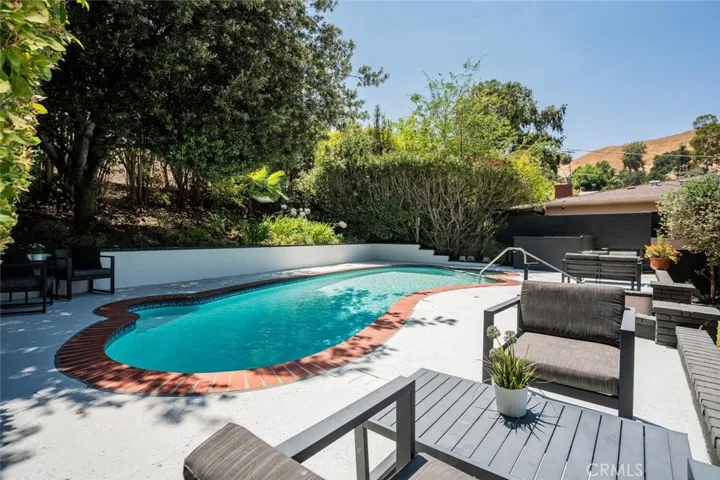 Pool and patio ideal for relaxing or entertaining in a private backyard setting.