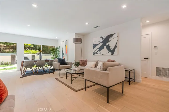 Bright open living room with wide glass doors opening to the backyard.