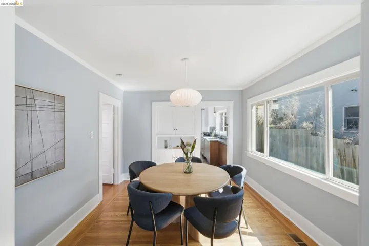 Dining area with light wood-style flooring and ornamental molding