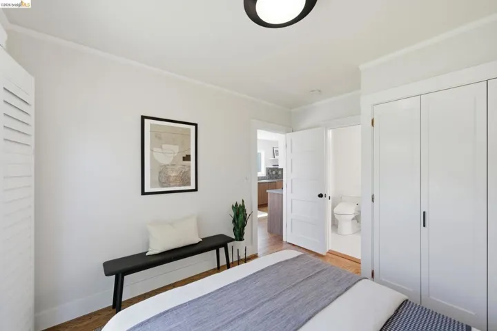 Bedroom featuring crown molding, light wood finished floors, and a closet