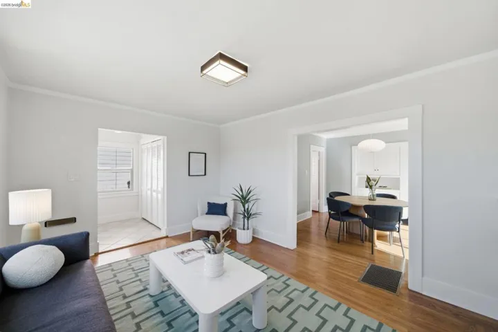 Living room with light wood-style flooring and ornamental molding