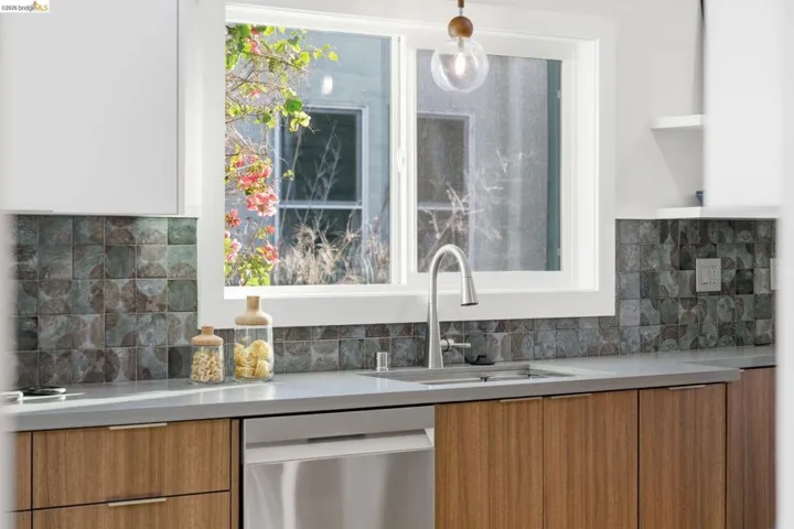 Bar featuring dishwasher, wood finish cabinetry, open shelves, light stone counters, and modern cabinets
