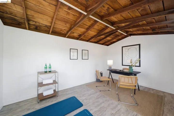 Office area featuring a wood ceiling with exposed beams and light wood-style floors