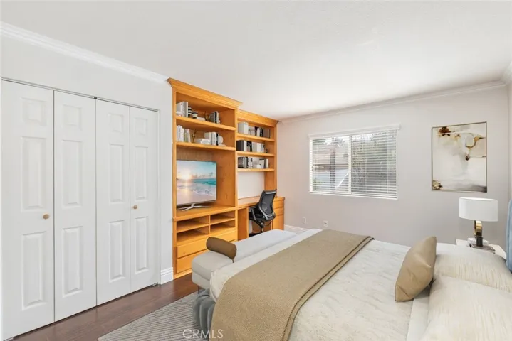 
This bedroom is a blend of comfort and productivity with its cozy bedding, ample natural light, and a well-organized, honey-toned wooden bookshelf that doubles as a workstation.