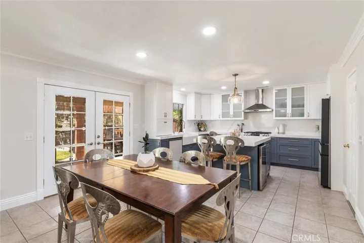 
A beautifully appointed kitchen featuring modern appliances and a classic dining area, bathed in natural light from the garden-facing French doors.
