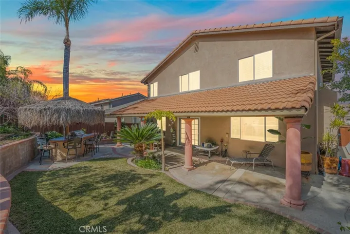 Neatly manicured lawn with a curved pathway leads to a charming patio