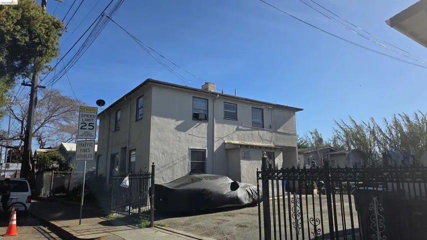Side of property featuring a fenced front yard, stucco siding, a gate, and a chimney