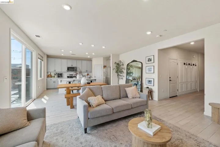 Living area with light wood finished floors and recessed lighting