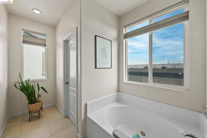 Full bathroom with a garden tub and light tile patterned flooring