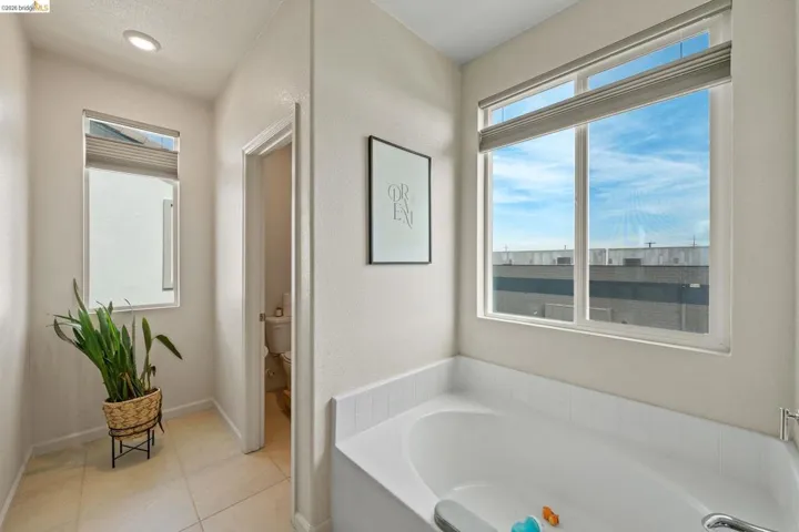 Bathroom with a bath and light tile patterned flooring