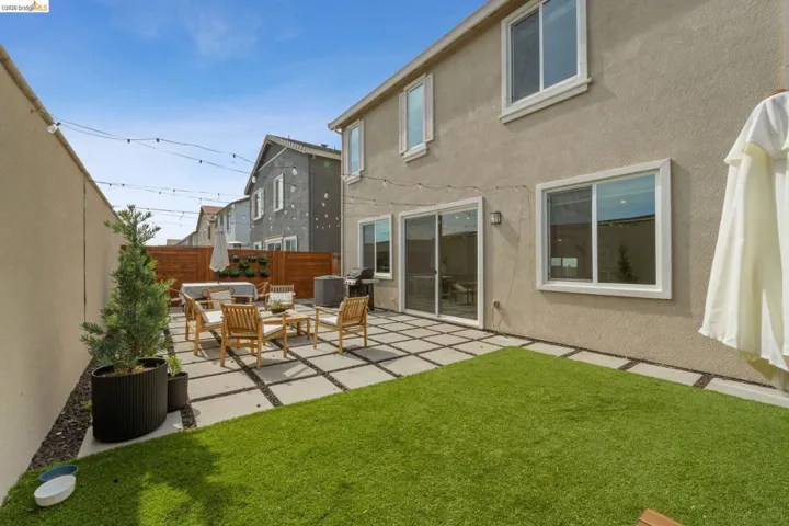 Back of house featuring a fenced backyard, stucco siding, and a patio area