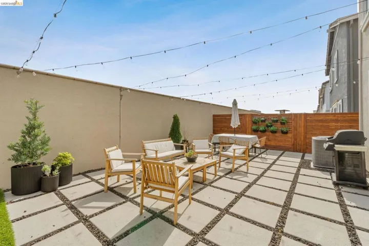 Fenced backyard with an outdoor lounge area and a grill