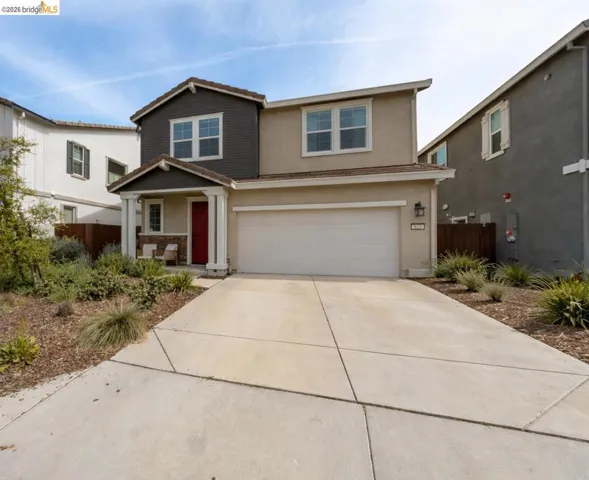 Traditional home with concrete driveway, stucco siding, a garage, and covered porch