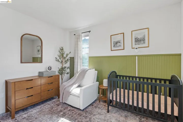 Bedroom featuring a wainscoted wall and a crib