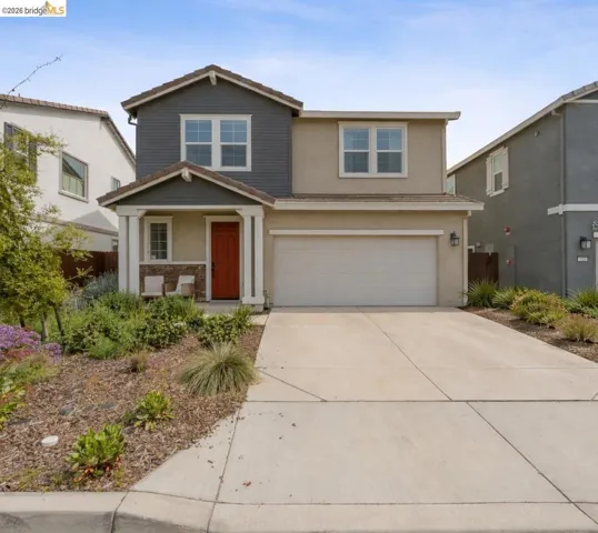 View of front facade with a porch, stucco siding, driveway, and a garage