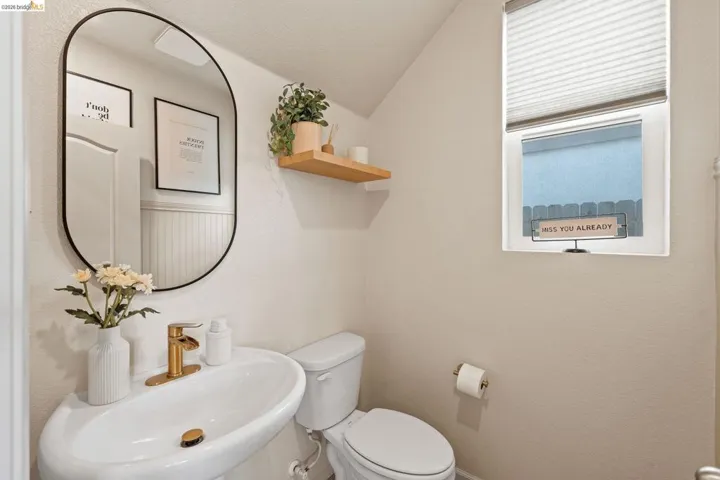 Half bath featuring toilet and lofted ceiling