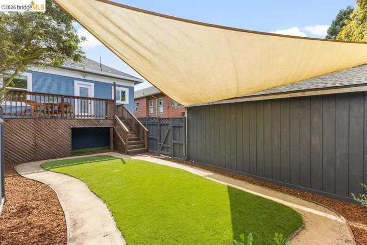 Rear view of house with a deck and a gate