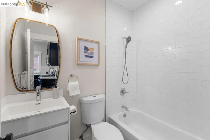 Bathroom featuring vanity,  shower combination, and a textured wall