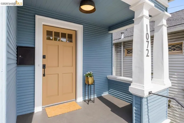 Entrance to property featuring covered porch and roof with shingles