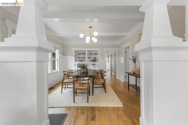Dining room featuring light wood-style floors, hanging lights, ornamental molding, and built in features