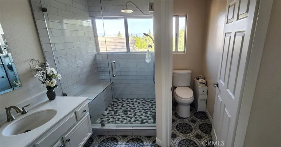 Primary bathroom with dual vanities and walk-in shower with 2 showerheads