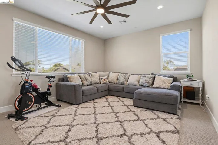 Living room featuring light carpet, ceiling fan, recessed lighting, and plenty of natural light