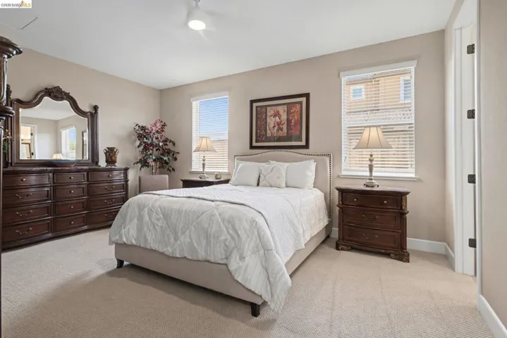 Bedroom featuring light carpet and multiple windows