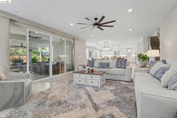 Living room with a ceiling fan, recessed lighting, and light tile patterned floors