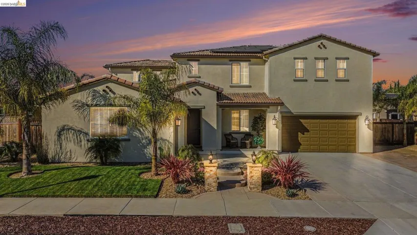 Mediterranean / spanish house featuring solar panels, concrete driveway, a garage, stucco siding, and a tile roof
