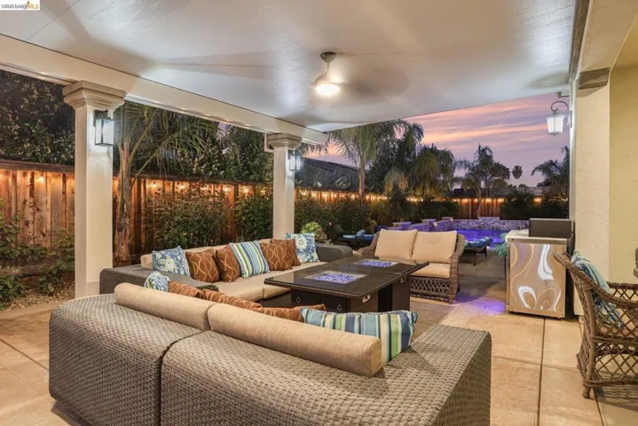 Fenced backyard featuring an outdoor living space with a fire pit and a patio
