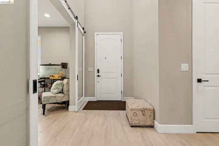Foyer featuring a barn door, light wood-style flooring, and recessed lighting
