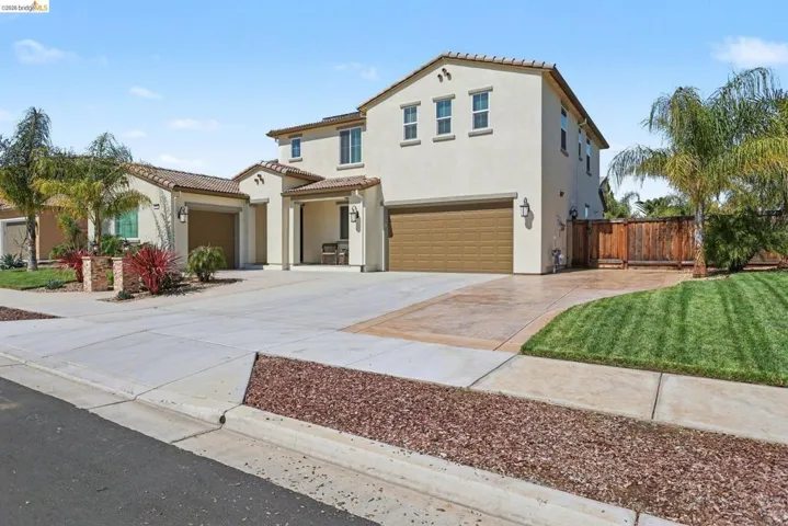 Mediterranean / spanish-style home with concrete driveway, stucco siding, a tiled roof, and an attached garage