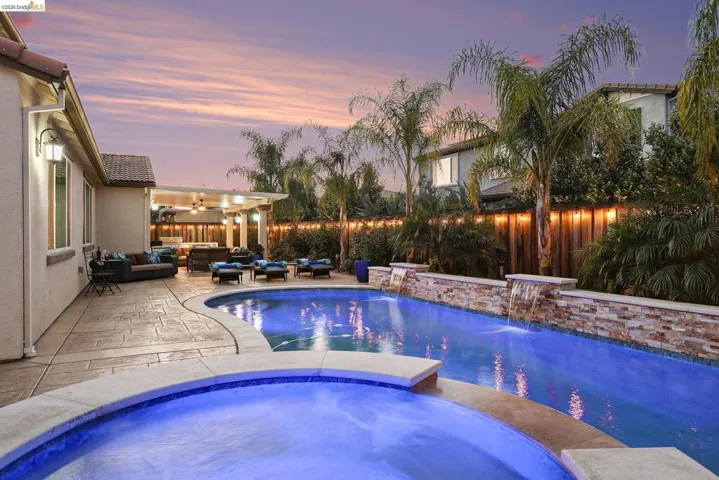 Relaxing pool / spa with an outdoor hangout area, a patio area, and a fenced backyard