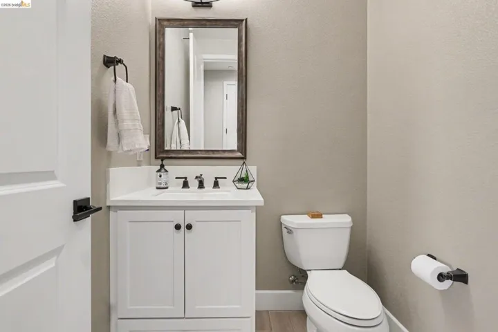 Half bathroom with vanity and a textured wall