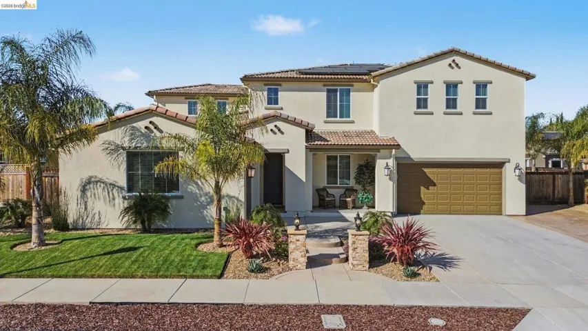 Mediterranean / spanish home featuring solar panels, an attached garage, concrete driveway, and stucco siding