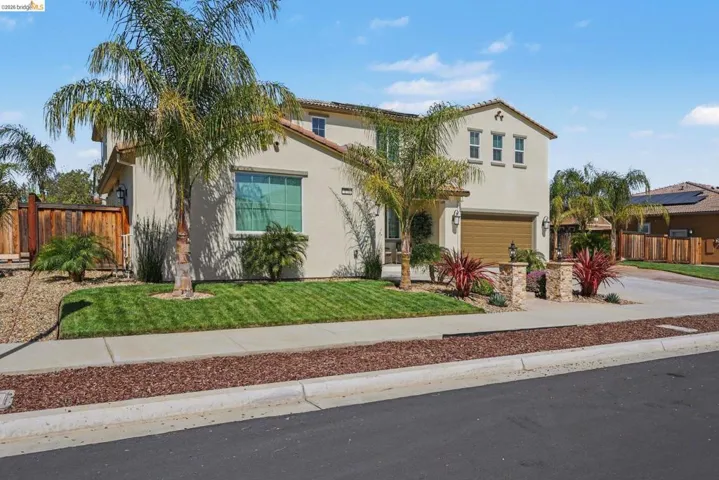 Mediterranean / spanish house with a garage, stucco siding, and concrete driveway