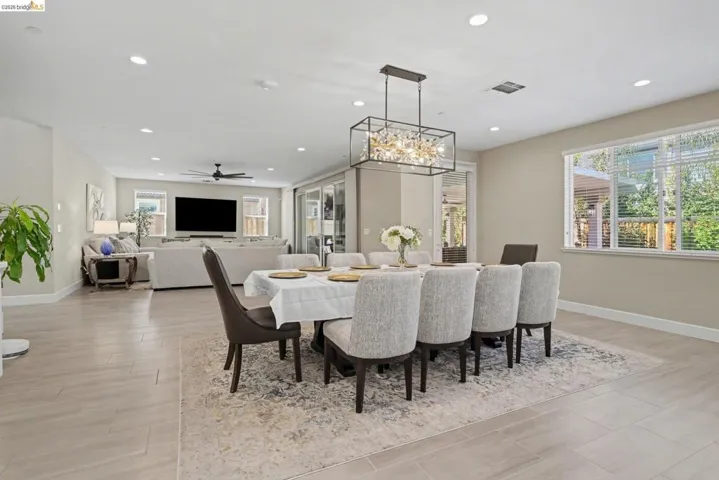 Dining area with ceiling fan, suspended lighting, and light wood-style floors