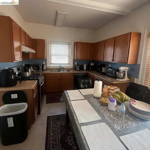 Kitchen featuring freestanding range oven, wood finish cabinets, light countertops, and stainless steel microwave