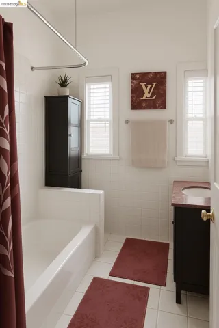 Full bathroom with vanity, tile walls, shower / bathtub combination with curtain, healthy amount of natural light, and light tile patterned floors