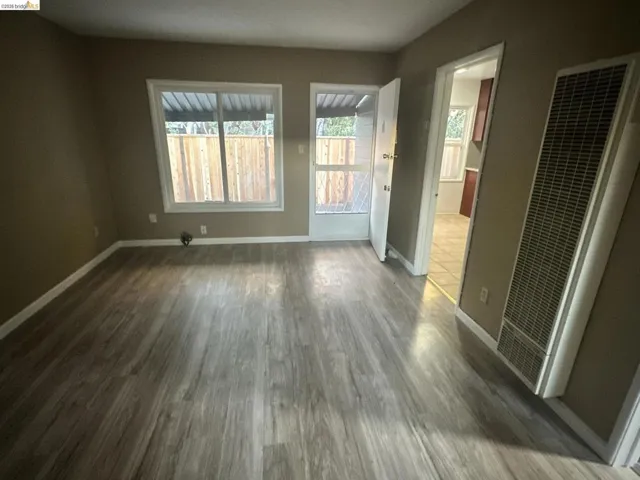 Unfurnished bedroom with a heating unit and dark wood-style flooring