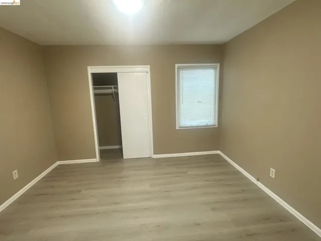 Unfurnished bedroom with light wood-style flooring and a closet