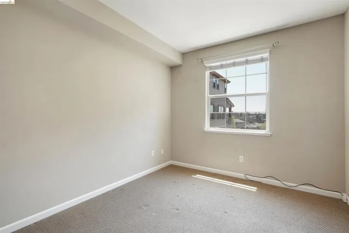 Spare room featuring baseboards and light carpet