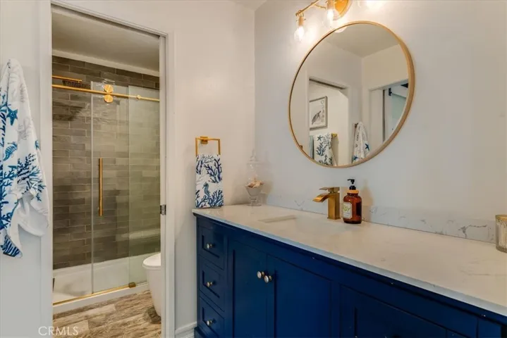 View of sink in primary bath looking at shower and toilet.