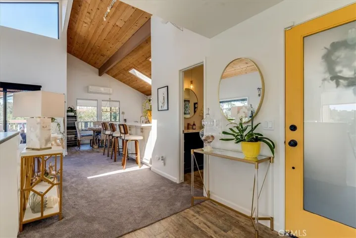 Inside front door showing kitchen, dining and door to bathroom.