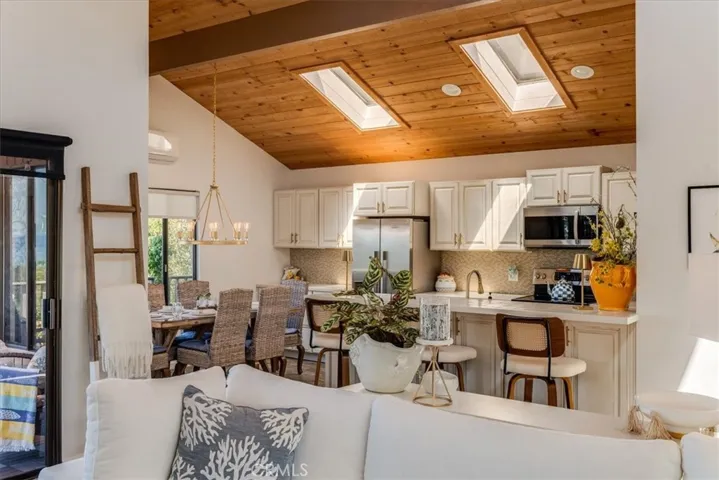 Closer view of kitchen with breakfast bar and dining area.