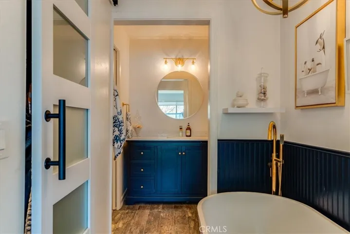 Primary bathroom showing tub. Door on left goes to primary bedroom closet.