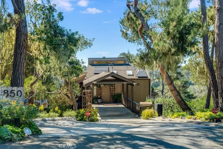 Other view from street showing parking spots in carport and separate spot on left. There is a fourth spot on the road in front of the house.