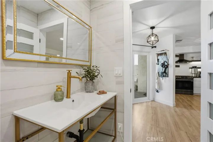 Upgraded bathroom with designer gold mirrors and industrial-style fixtures